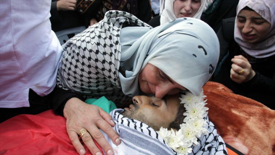 Madre se despide de su hijo Eyad Awawda, joven palestino asesinado a manos de los israelíes en Cisjordania. 17 de octubre de 2015.