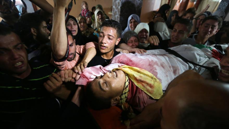 Dolientes palestinos llevan el cuerpo de Mahmud Homaida, asesinado por militares israelíes durante los enfrentamientos acaecidos el 17 de octubre de 2015. 18 de octubre de 2015.