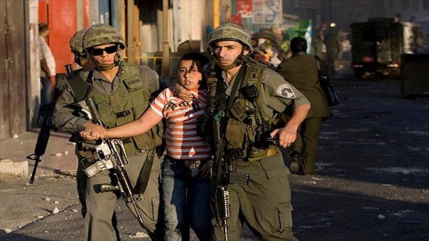Fuerzas israelíes detienen a un niño palestino en Al-Quds (Jerusalén).
