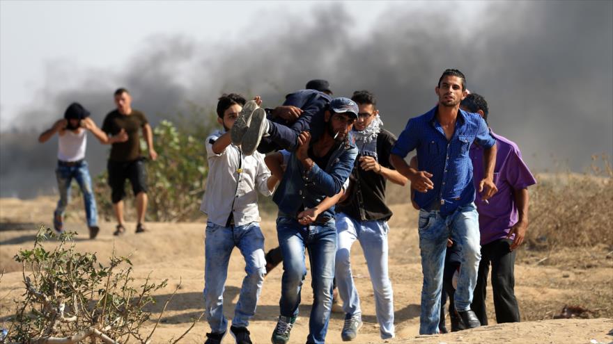 Manifestantes palestinos trasladan a un compañero suyo, herido por disparos de las fuerzas israelíes en Gaza.