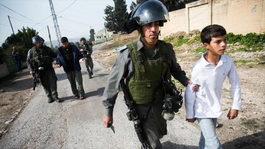 Las fuerzas de seguridad israelíes detienen a un niño palestino en la localidad de Kafr Qadum, en el norte de la ocupada Cisjordania.