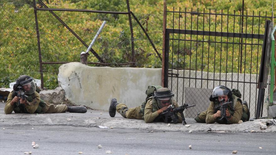 Fuerzas israelíes apuntan sus armas contra los manifestantes palestinos en la ocupada Cisjordania.