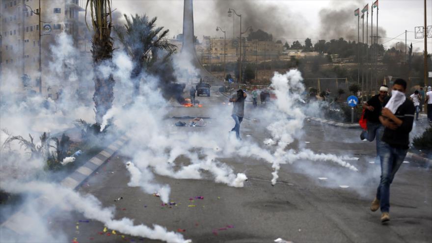 Fuerzas del régimen israelí lanzan gases lacrimógenos contra palestinos en Al-Bireh, al norte de Al-Quds (Jerusalén), 23 de octubre de 2015.