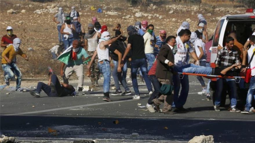 Un joven palestino herido por disparos israelíes cerca de un puesto de control militar, en la ciudad de Ramalá.