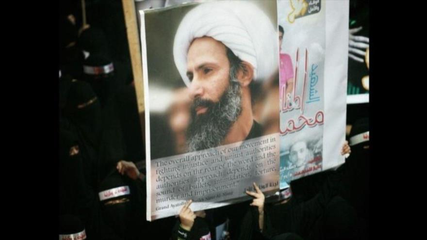 Manifestantes saudíes portan imágenes del prominente sheij chií Nimr Baqer al-Nimr, en una marcha por su liberación.