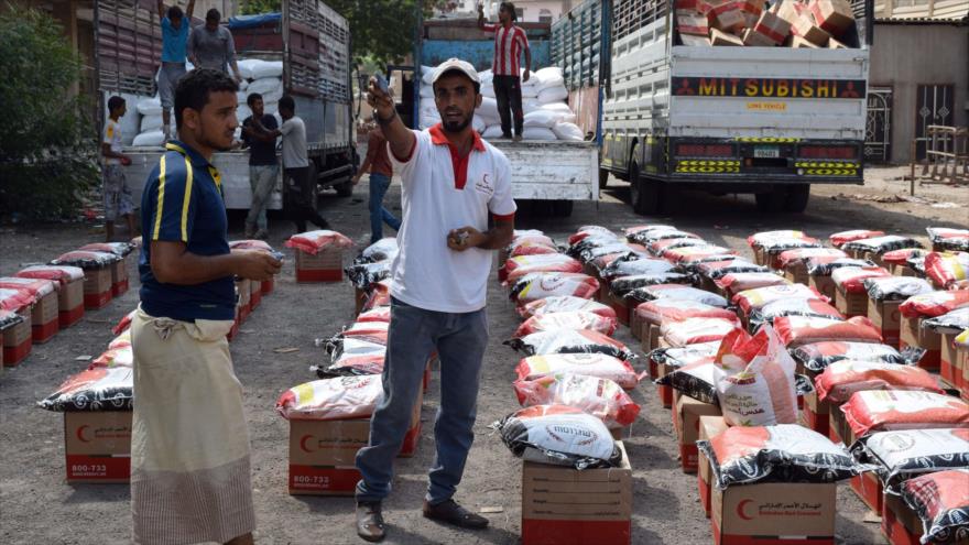 Yemeníes descargan paquetes de alimentos proporcionados por la Media Luna Roja. 28 de octubre de 2015