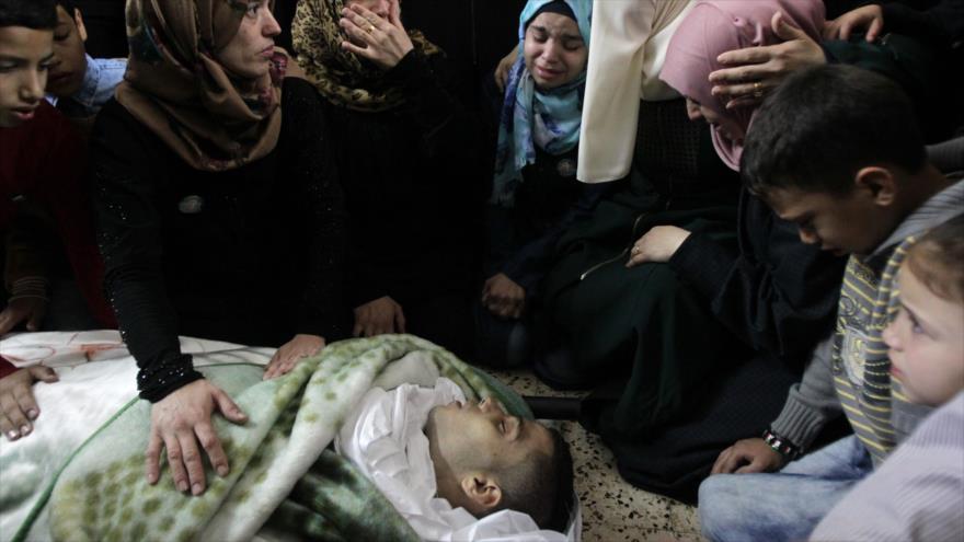 Familiares del palestino Tareq al-Natsheh, de 17 años asesinado por israelíes, se despiden de él antes de su funeral en Al-Jalil (Hebron), 31 de octubre de 2015.