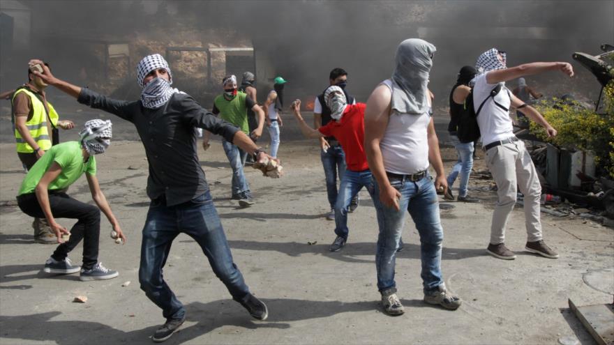 Manifestantes palestinos arrojan piedras a soldados israelíes ante sus brutales medidas de represión.