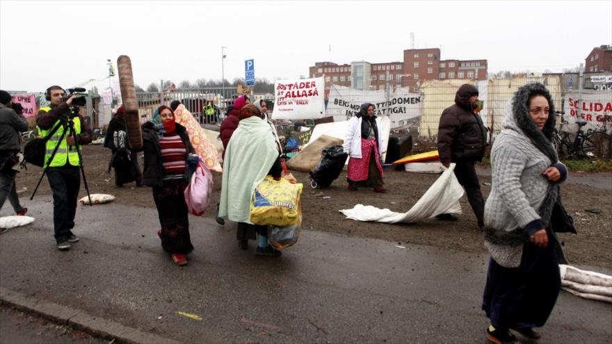 Refugiados abandonan un campamento después de una redada de la Policía sueca en la ciudad sureña de Malmo.