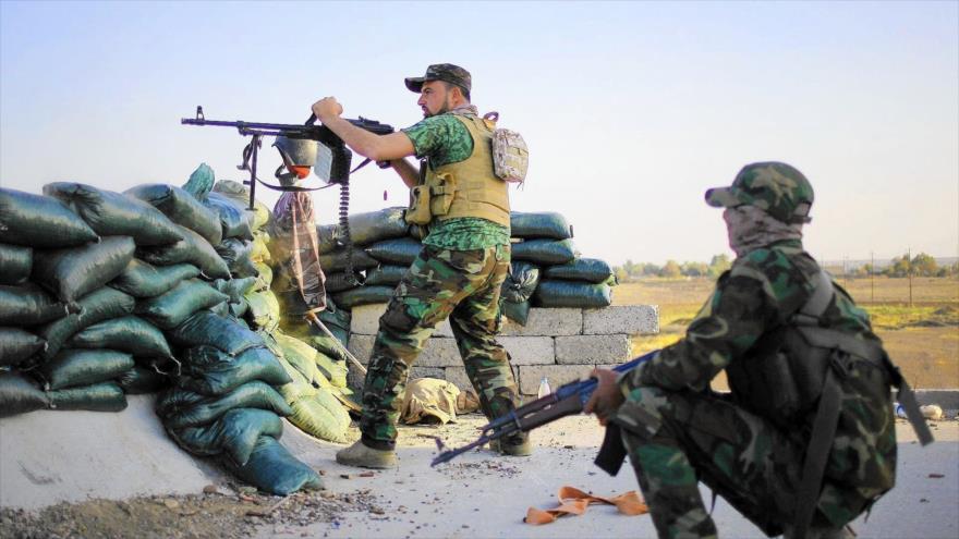 Fuerzas populares iraquíes disparan contra terroristas de Daesh.