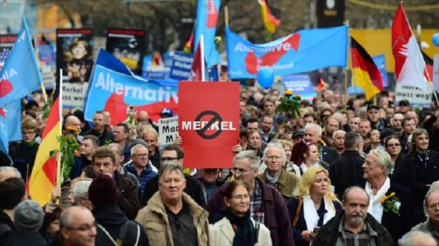 Un partidario del partido Alternative für Deutschland (AFD) muestra una pancarta anti-Merkel durante una manifestación en contra de la política de asilo del Gobierno alemán en la capital Berlin. 7 de noviembre de 2015