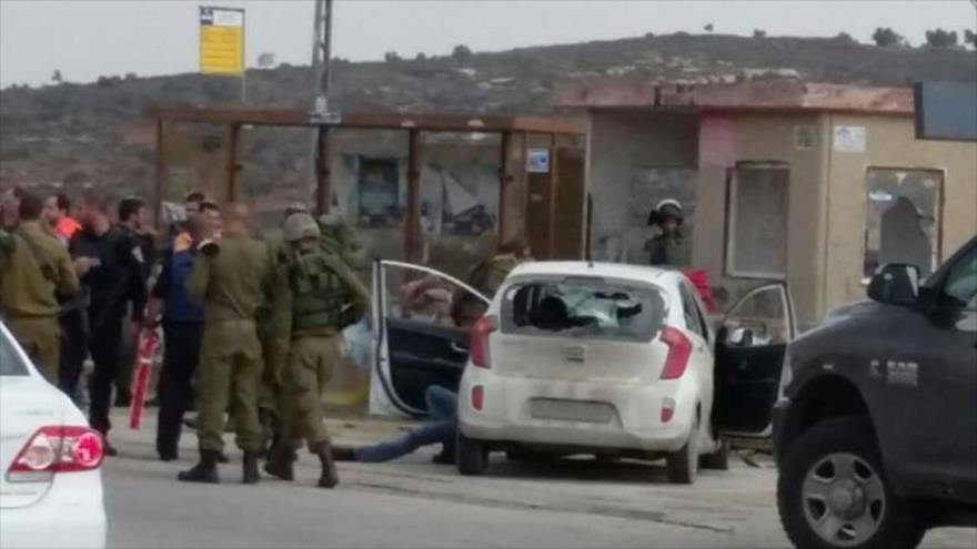 Soldados israelíes reunidos alrededor del cuerpo de sin vida de un palestino, acusado de embestir con su auto a un grupo de colonos israelíes al sur de la ciudad cisjordana de Nablus. 8 de noviembre de 2015.