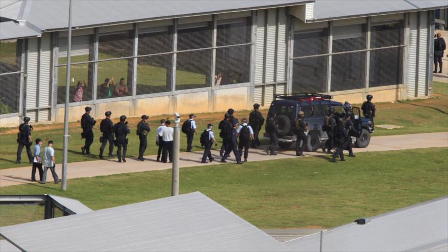 Agentes de la Policía Federal australiana custodian el centro de detención en la isla de Navidad tras los disturbios entre los solicitantes de asilo detenidos, 21 de marzo de 2015.