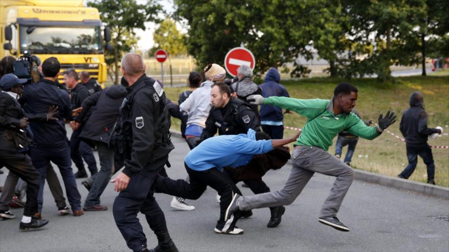 Enfrentamiento entre la Policía francesa y un grupo de refugiados en Calais.