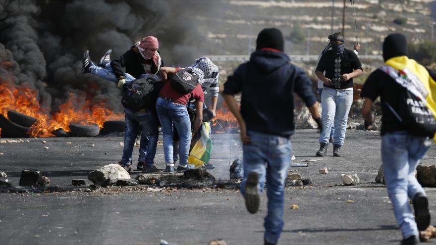Palestinos trasladan el cuerpo de un herido en los enfrentamientos con fuerzas israelíes en las cercanías de la ciudad de Ramalá, en la ocupada Cisjordania, 11 de noviembre de 2015.