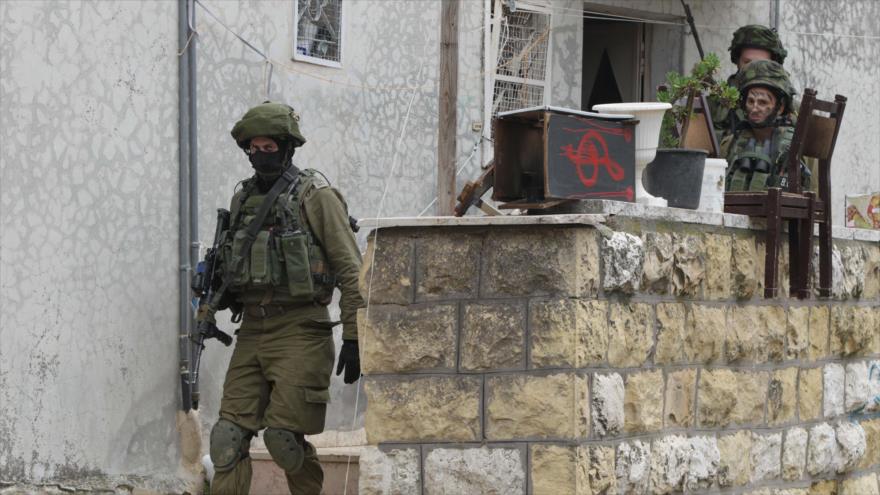 Soldados del ejército israelí inspeccionan casas palestinas en la ciudad de Al-Jalil (Hebrón).