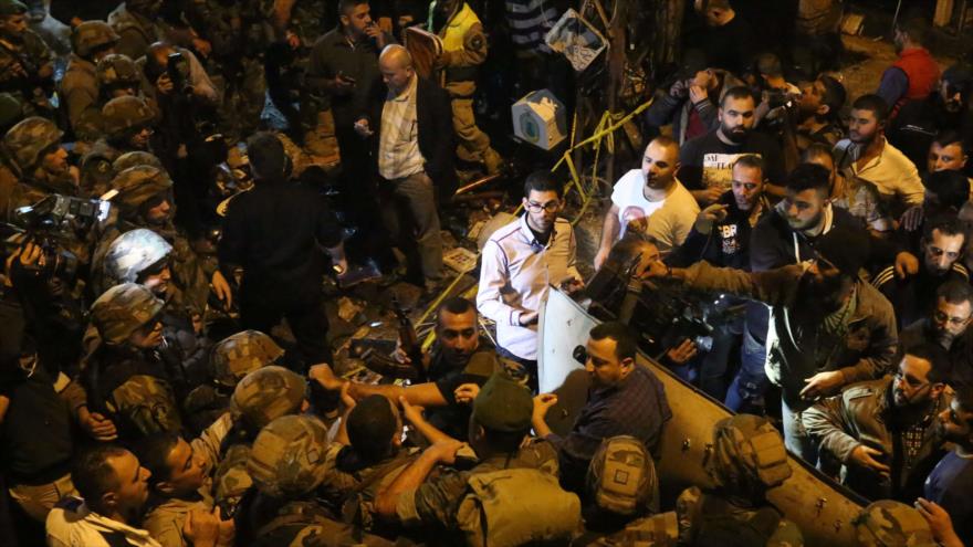 Civiles y soldados del Ejército libanés se concentran en el lugar de un doble atentado en el suburbio chií de Bourj el-Barajneh, al sur de Beirut, capital libanesa, 12 de noviembre de 2015.