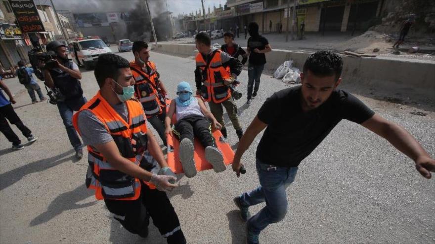 Equipos de rescate trasladan a un palestino herido en choques con soldados israelíes a un hospital en Ramalá.