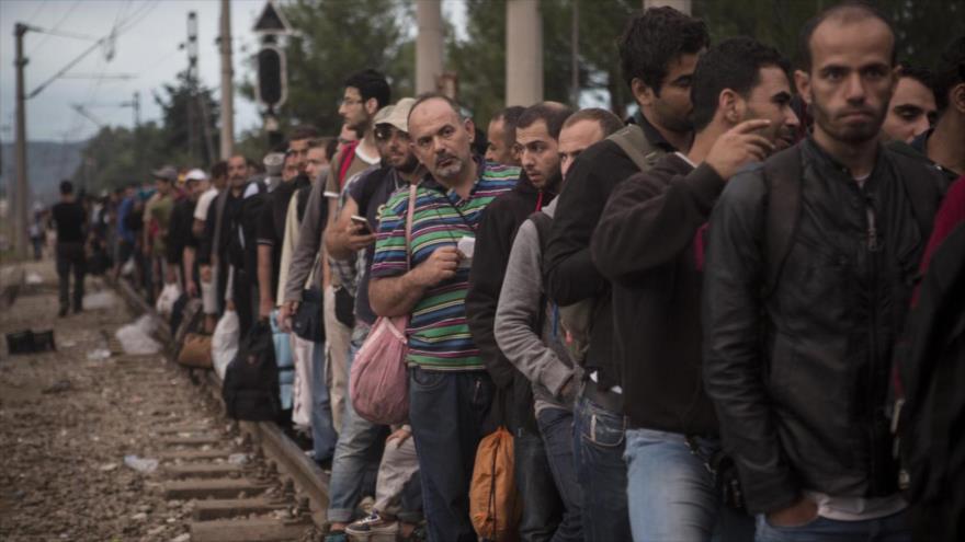 Demandantes de asilo sirios hacen cola en la estación de tren de Idomani en Grecia para cruzar la frontera hacia Europa.
