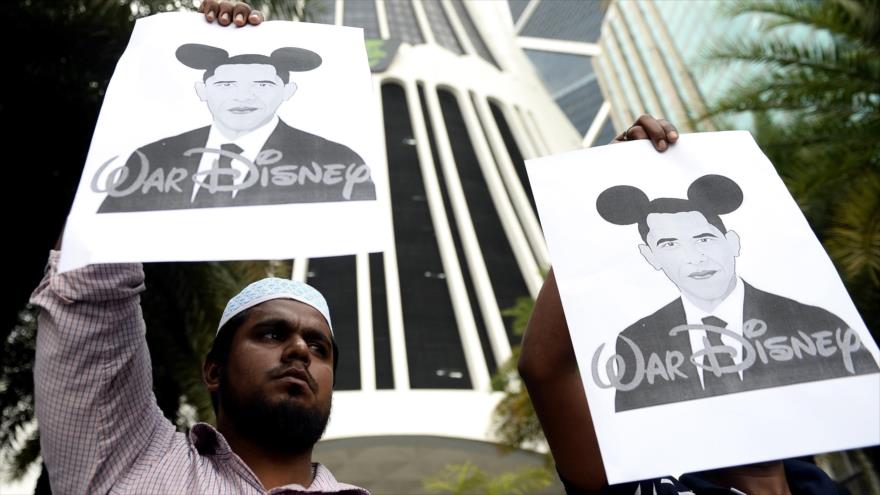 Activistas de Malasia muestran pancartas con imágenes del presidente de EE.UU., Barack Obama, retratado como Mickey Mouse durante una protesta cerca de la embajada del país norteamericano en Kuala Lumpur (capital). 20 de noviembre de 2015