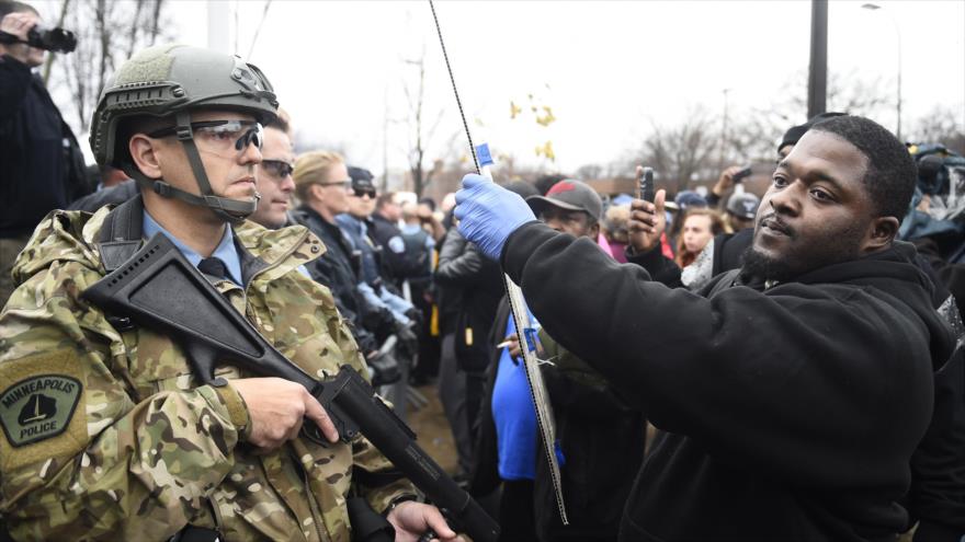 Un manifestante ante la Policial de Minneapolis, protestando por la muerte del ciudadano afroamericano Jamar Clark.