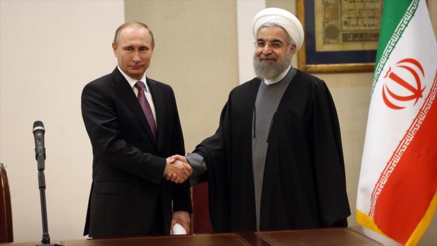 El presidente de Irán, Hasan Rohani, (derecha) y su homólogo ruso, Vladimir Putin, en una rueda de prensa al término de la III cumbre del Foro de Países Exportadores de Gas (FPEG), celebrada en Teherán, capital persa, 23 de noviembre de 2015.