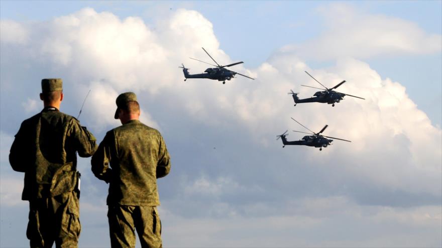 Soldados rusos presencian el vuelo de helicópteros Mi-8 rusos.