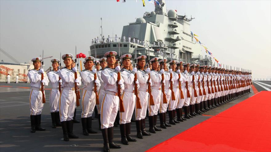 Una guardia de honor al lado del portaaviones chino Liaoning.