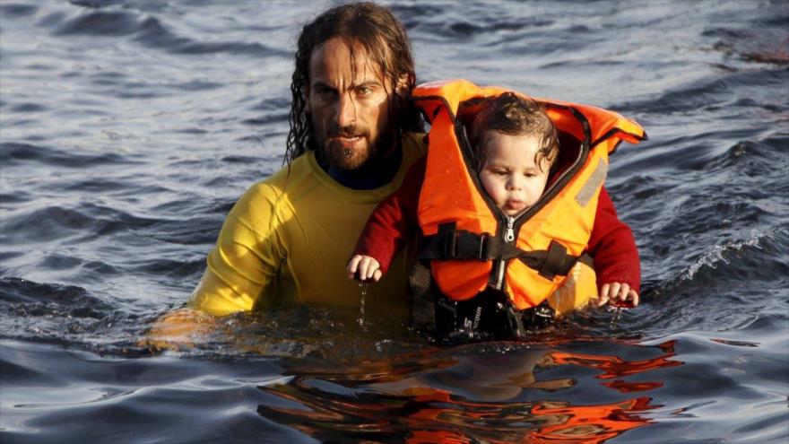 El salvavidas voluntario argentino Nicolás Migueiz socorre a un bebé en las frías aguas frente a la isla griegas de Lesbos. 30 de octubre de 2015