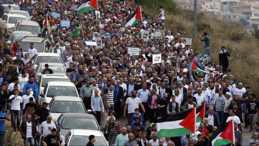 Miles de personas ondean las banderas palestinas durante una protesta contra la ilegalización del Movimiento Islámico por el régimen de Israel en Um al-Fahm, a las afueras de Haifa, en el norte de los territorios ocupados palestinos. 28 de noviembre de 2015
