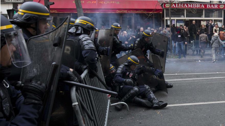 Policías anti disturbios se caen durante choques con manifestantes tras una marcha por el calentamiento global en París, un día antes del inicio de la Cumbre del Clima (COP21), 29 de noviembre de 2015.