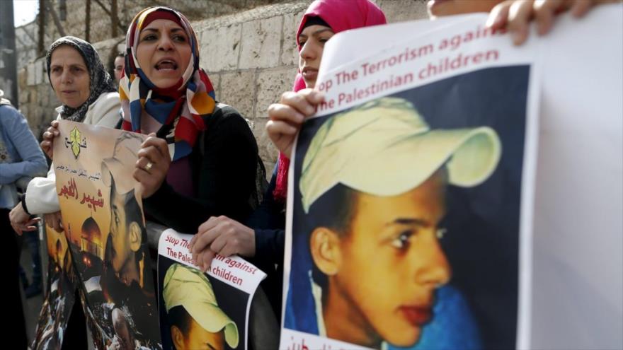 Dolientes palestinos portan imágenes del adolescente palestino secuestrado y quemado vivo por colonos israelíes, en una manifestación frente a un tribunal israelí, 30 de noviembre de 2015, Jerusalén.
