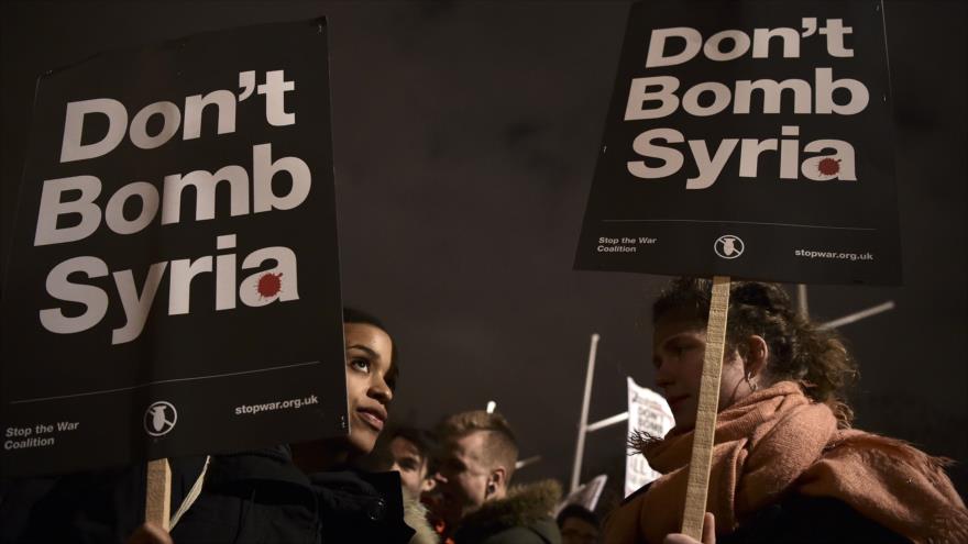 Manifestantes sostienen pancartas con lemas como “No bombardear Siria” durante una marcha contra la acción militar del Reino Unido en Siria en los alrededores de la sede del Parlamento en Londres, capital británica, el 1 de diciembre de 2015.