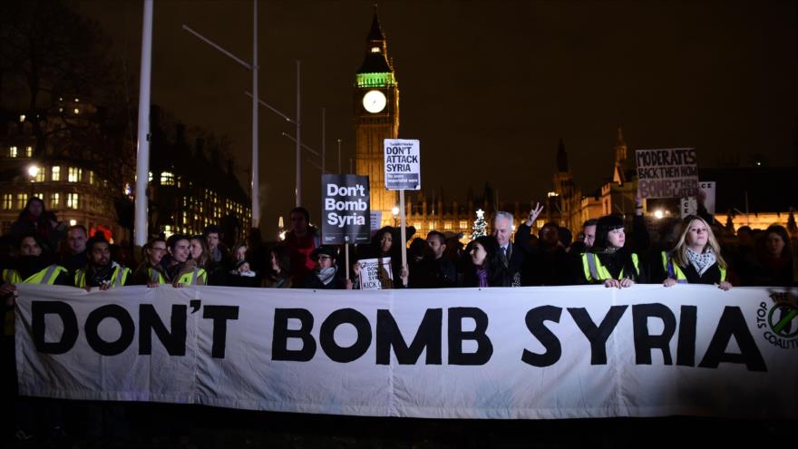 Manifestantes sostienen pancartas con lemas como “No bombardear Siria” durante una marcha contra la acción militar del Reino Unido en Siria en los alrededores de la sede del Parlamento en Londres, capital británica, el 1 de diciembre de 2015.