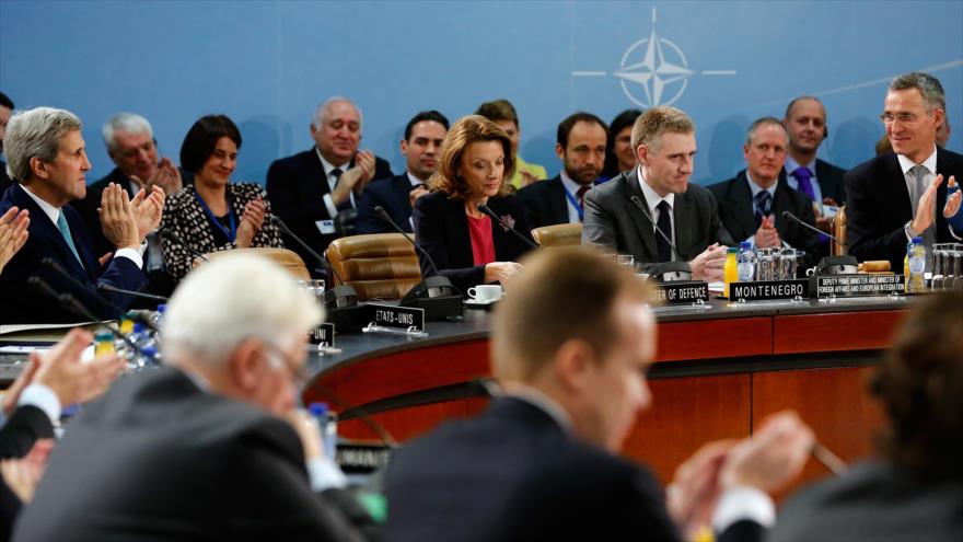 El secretario de Estado estadounidense, John Kerry, (1º izda) y el secretario general de la OTAN, Jens Stoltenberg, (1º drcha) aplauden un discurso pronunciado por el canciller de Montenegro, Igor Luksic, (2º drcha) en la cumbre de la OTAN celebrada en Bruselas (capital de Bélgica), 2 de diciembre de 2015.