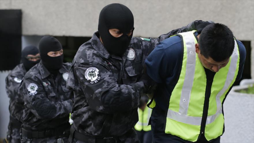 Agentes federales escoltan a un policía detenido en relación con la desaparición de los 43 normalistas, 17 de octubre de 2014.
