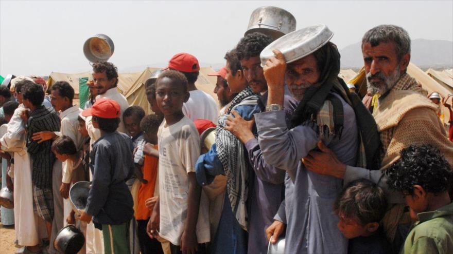 Yemeníes hacen cola para recibir ayuda alimentaria.
