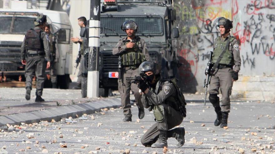 Un soldado israelí apunta a varios palestinos durante una protesta en la ciudad cisjordana de Belén.