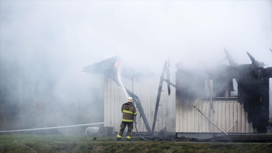 Un bombero participa en la extinción de un incendio en un albergue de refugiados en Alemania.