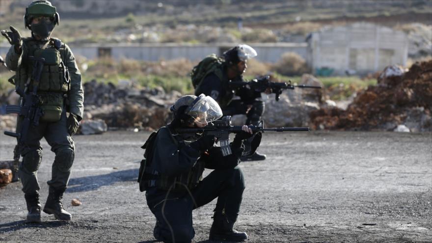 Soldados israelíes apuntan contra palestinos participantes en una manifestación en Cisjordania.