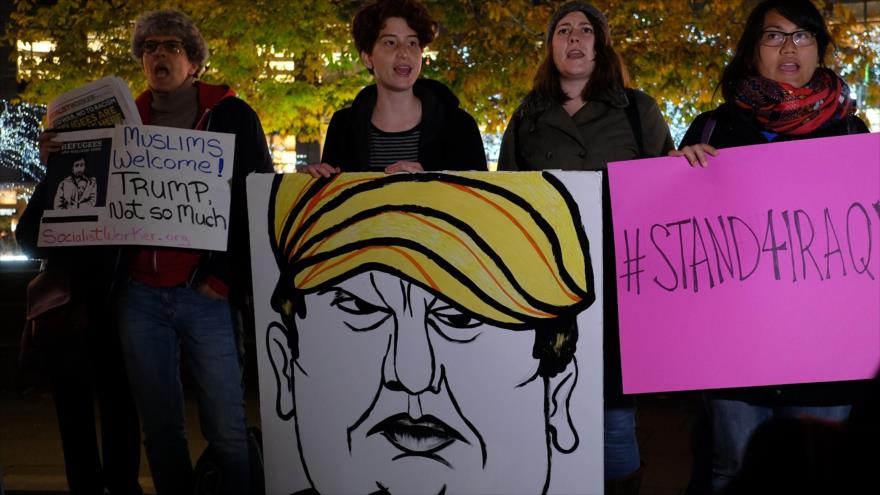 Activistas pro derechos humanos y miembros de la comunidad musulmana sostienen pancartas en contra de las declaraciones antimusulmanes del candidato presidencial Donald Trump durante una manifestación de solidaridad con los refugiados sirios e iraquíes en Nueva York, 10 de diciembre de 2015.
