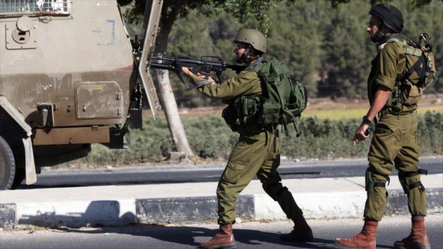 Un militar israelí dispara con su fusil contra manifestantes palestinos en Gaza.