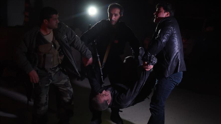 Cuerpos de seguridad afganos llevan a un hombre herido en el lugar de un ataque junto a la embajada española en Kabul, 11 de diciembre de 2015.