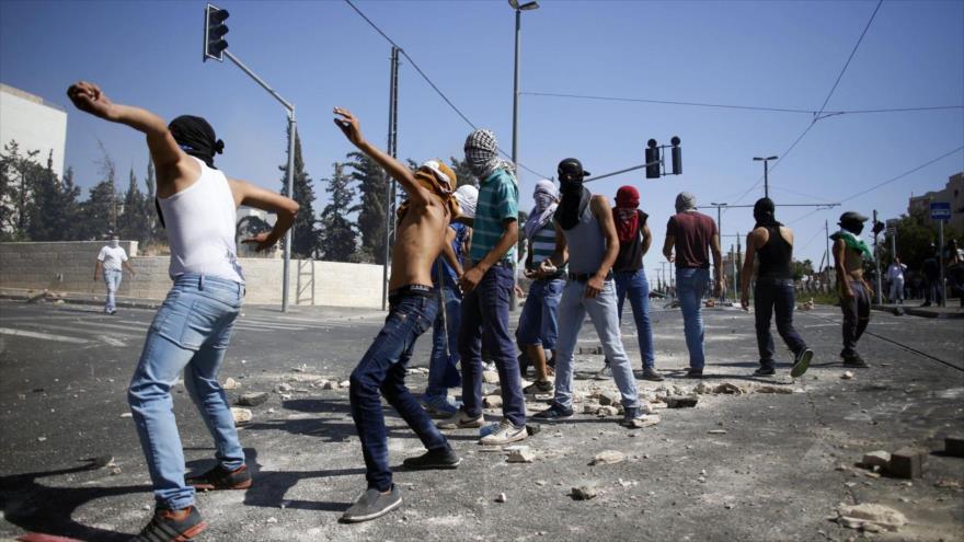 Un grupo de manifestantes palestinos lanza piedras contra las fuerzas israelíes en Al-Quds.