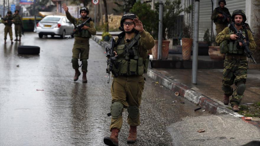 Soldados del régimen israelí desplegados en la ciudad cisjordana de Hebrón.
