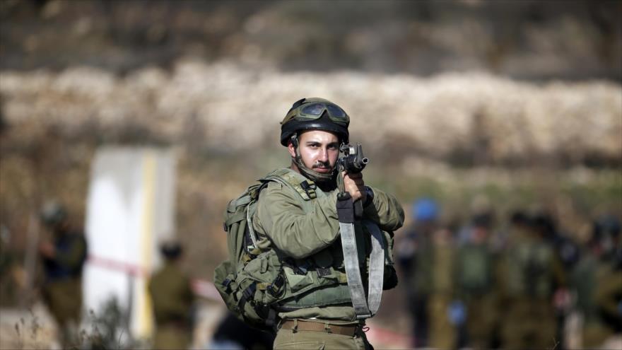 Soldado israelí apunta contra los palestinos en una manifestación en Cisjordania ocupada.