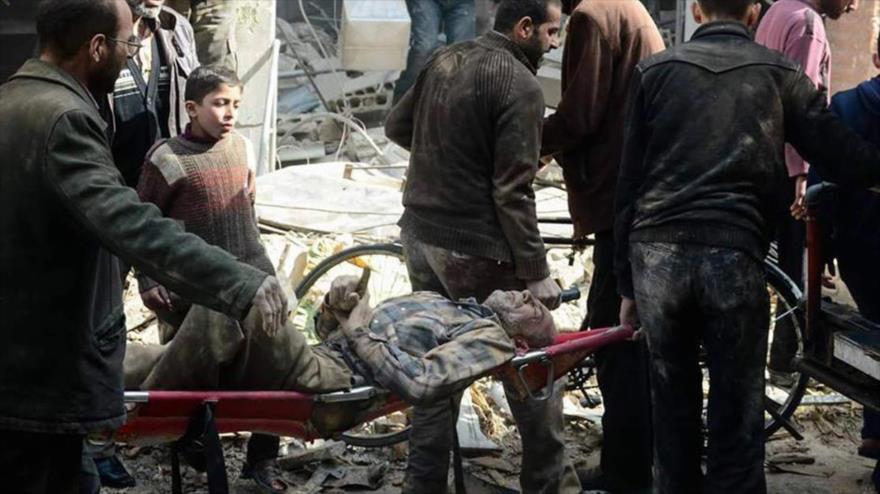 Civiles sirios portan a un ciudadano herido en un ataque terrorista.