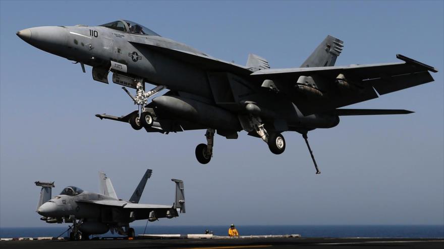 Un caza F-18E aterriza en el portaaviones estadounidense USS George H. W. Bush.