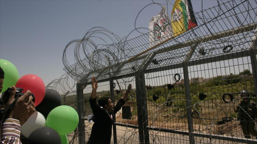 Activistas palestinos protestan ante una prisión israelí para reivindicar la liberación de varios de sus compatriotas detenidos.
