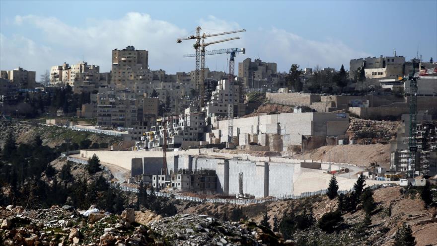 Una vista general tomada de la aldea palestina de Hizma muestra grúas de construcción y excavadoras edificando nuevas viviendas ilegales israelíes en la ciudad cisjordana de Al-Quds (Jerusalén), 30 de enero de 2015.